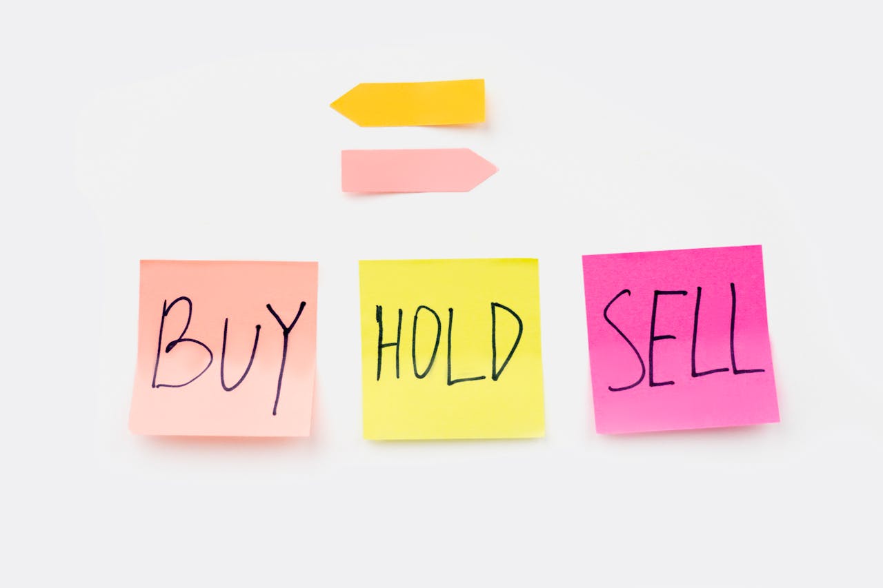 Colorful sticky notes with financial terms Buy, Hold, and Sell on a clean white backdrop.