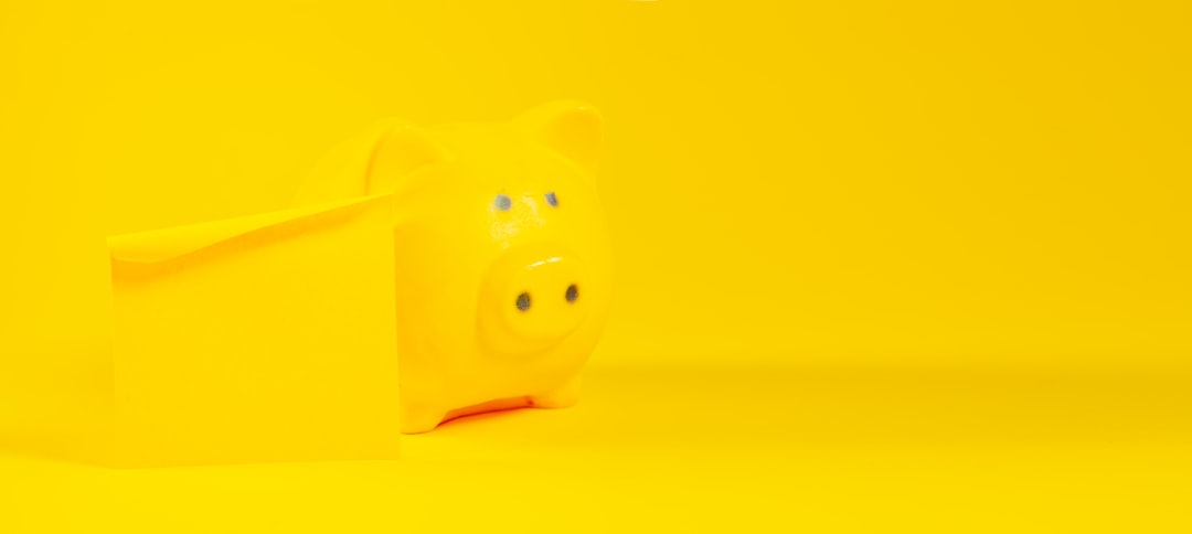 Piggy bank on yellow background with copy space for text.